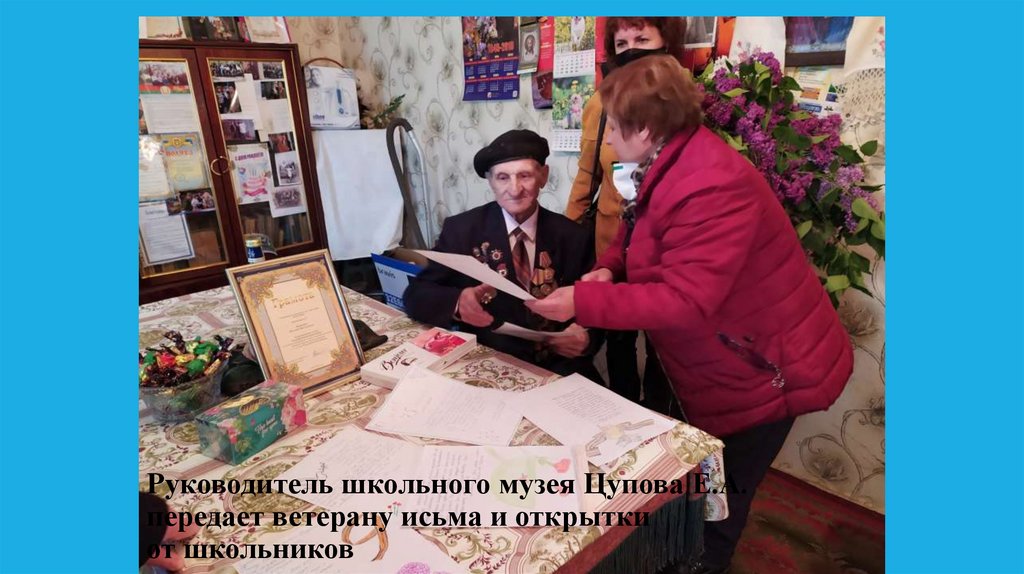 Руководитель школьного музея Цупова Е.А. передает ветерану исьма и открытки от школьников